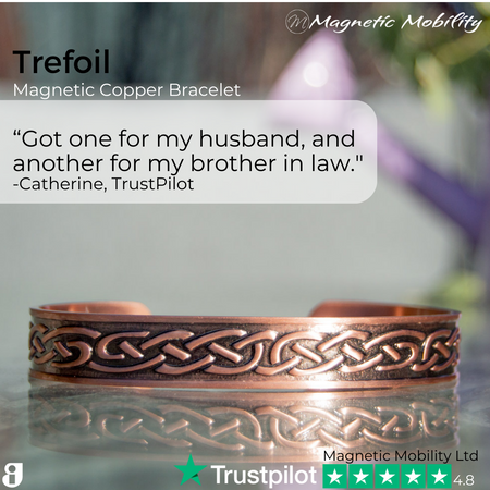 view of the Trefoil Copper bracelet from Magnetic Mobility. A copper bracelet with a celtic design. The bracelet is shown on a reflective surface in a garden. Perfect for people with arthritis and back pain. 99% pure copper. Customer review written on the image from Trustpilot stating "Got one for my husband and another for my brother in law". 